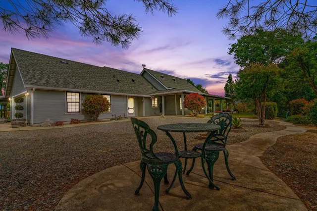 a view of a house with backyard and a tree