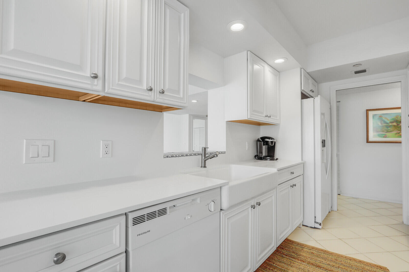 4100 North Ocean Drive, Unit 1501 Singer Island, FL 33404 - Photo 13 of 37 a kitchen with white cabinets and a sink