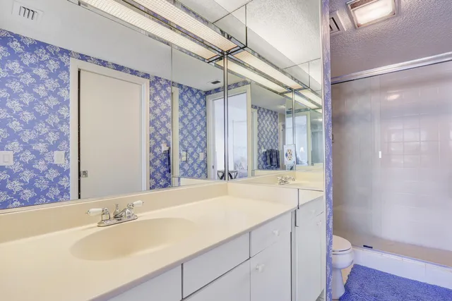 a bathroom with a granite countertop sink toilet and shower