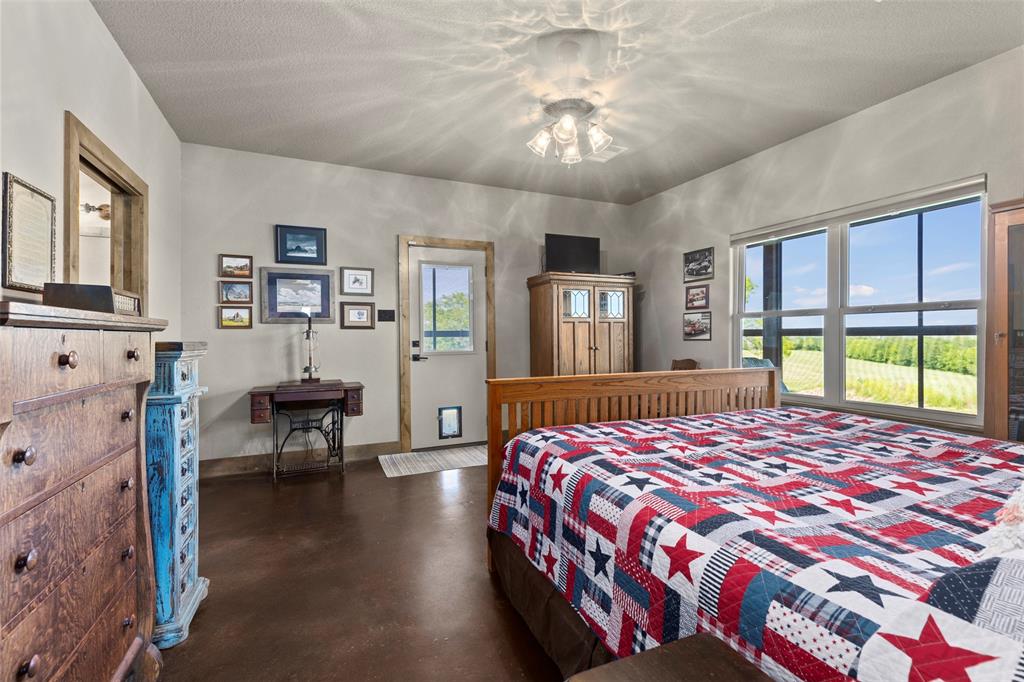 5555 Wright Road Sherman, TX 75092 - Photo 30 of 40 a bedroom with a bed and a chandelier