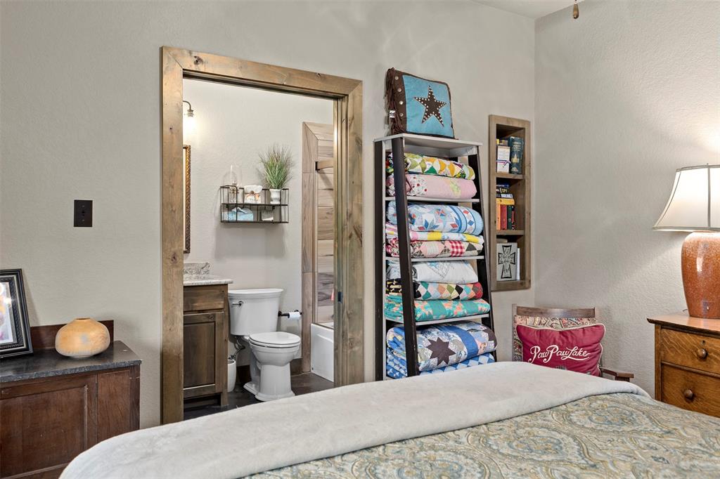 5555 Wright Road Sherman, TX 75092 - Photo 33 of 40 a bedroom with a bed and a book shelf