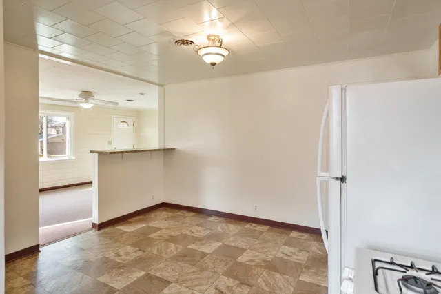 a view of kitchen with refrigerator stove and cabinets