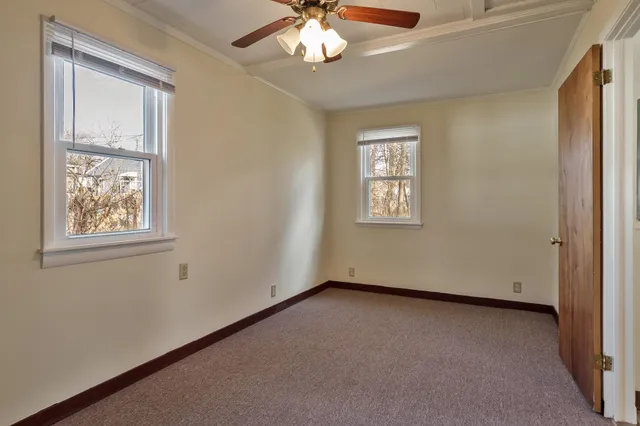 an empty room with closet and a chandelier fan