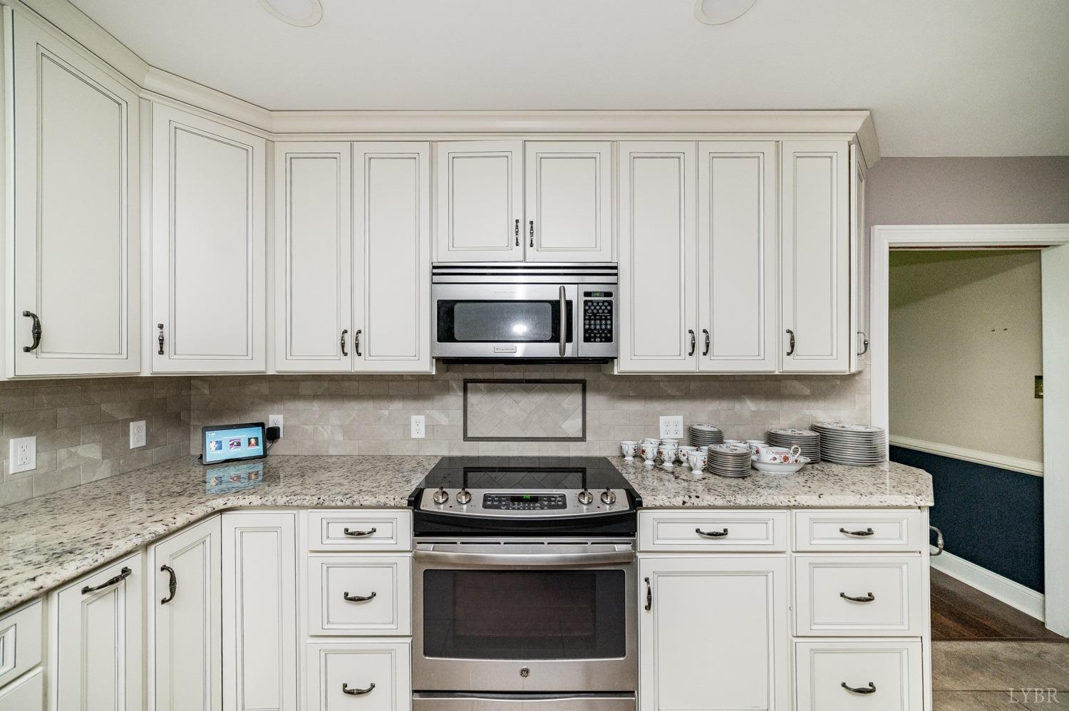 2901 Goode Station Road Goode, VA 24556 - Photo 54 of 57 a kitchen with granite countertop white cabinets and stainless steel appliances