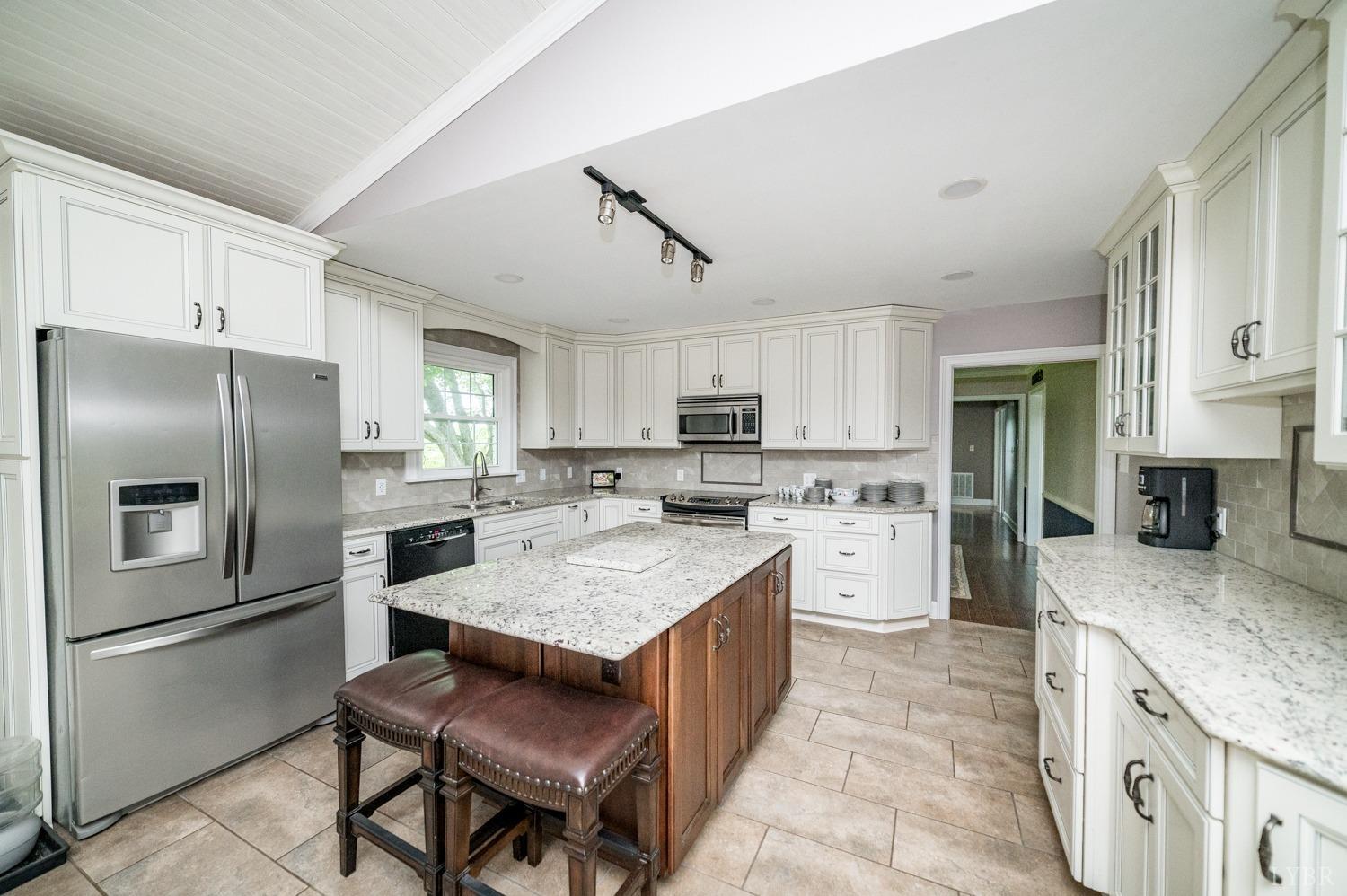 2901 Goode Station Road Goode, VA 24556 - Photo 57 of 57 a large kitchen with stainless steel appliances granite countertop a stove top oven a refrigerator a sink and dishwasher