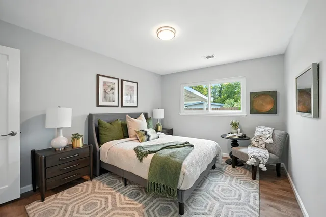 a bedroom with a bed and wooden floor