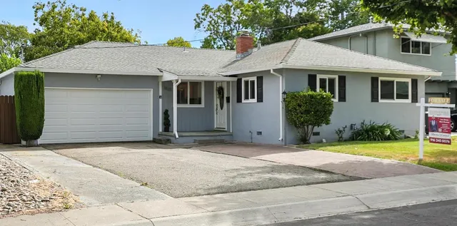 a view of a white house with a yard and large tree