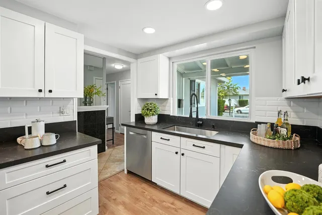 a kitchen with granite countertop white cabinets and white appliances
