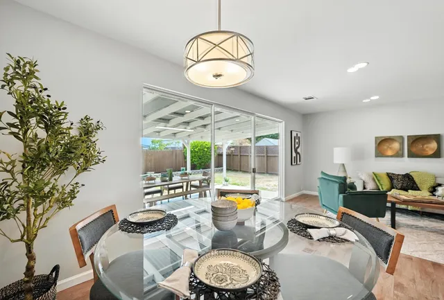 a view of a dining room with furniture a chandelier and wooden floor