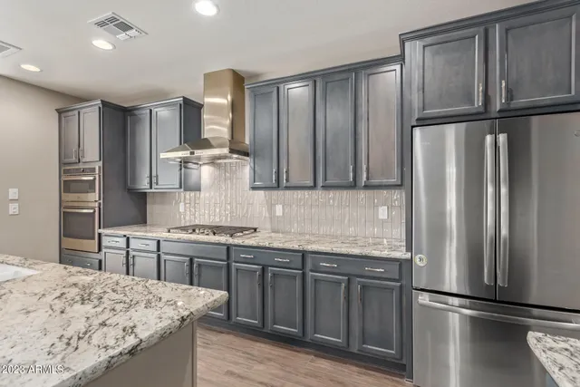 a kitchen with stainless steel appliances granite countertop a refrigerator and a sink