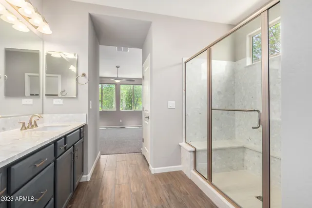 a bathroom with a granite countertop shower sink and mirror