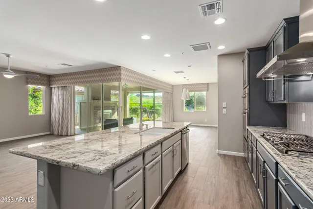 a kitchen with granite countertop sink stove and refrigerator