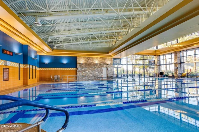 a swimming pool with outdoor seating and a garden