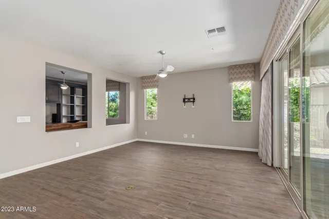 an empty room with wooden floor and windows