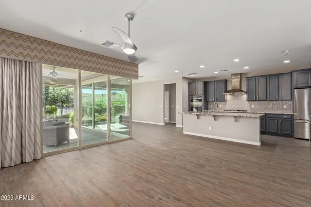 a large kitchen with kitchen island a large window a sink and cabinets