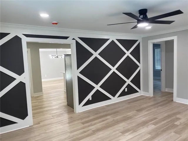 an empty room with wooden floor and a ceiling fan