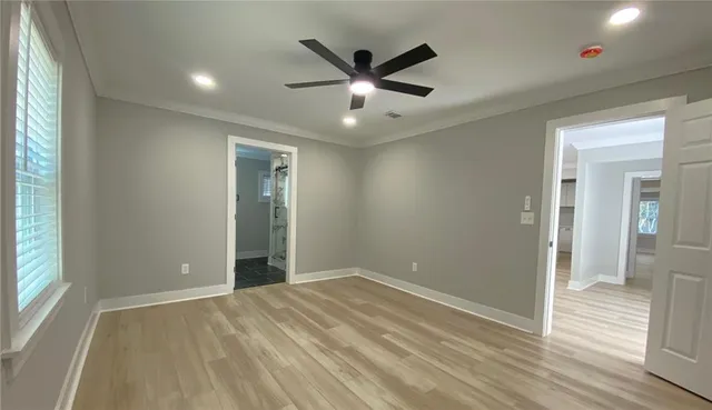 an empty room with wooden floor and windows