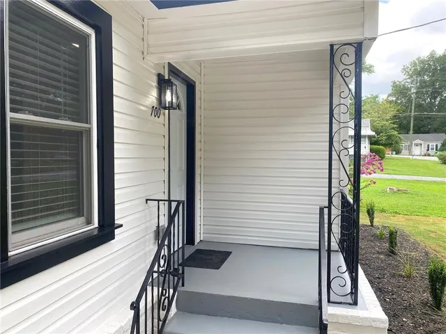 a view of a porch with a door and wooden floor
