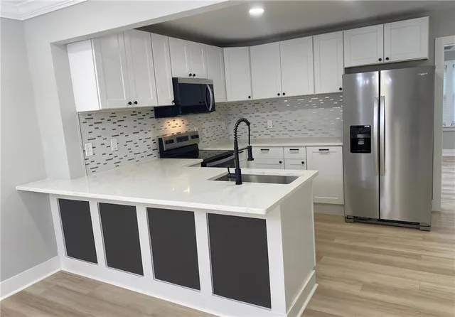 a kitchen with stainless steel appliances a refrigerator stove microwave and sink