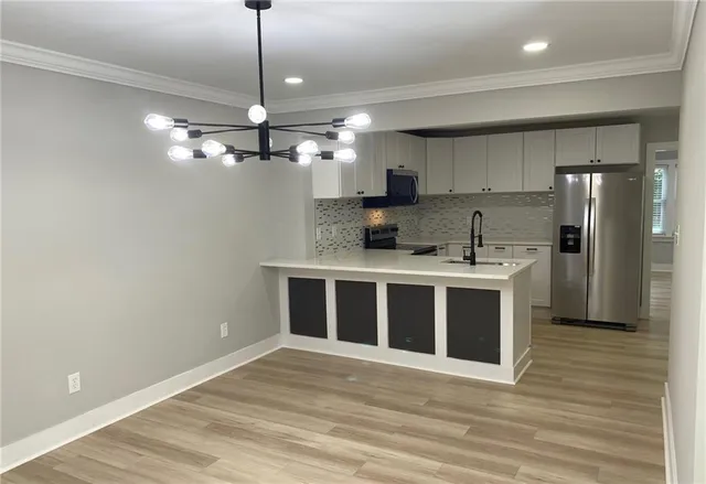 a view of a kitchen with a sink stainless steel appliances and cabinets