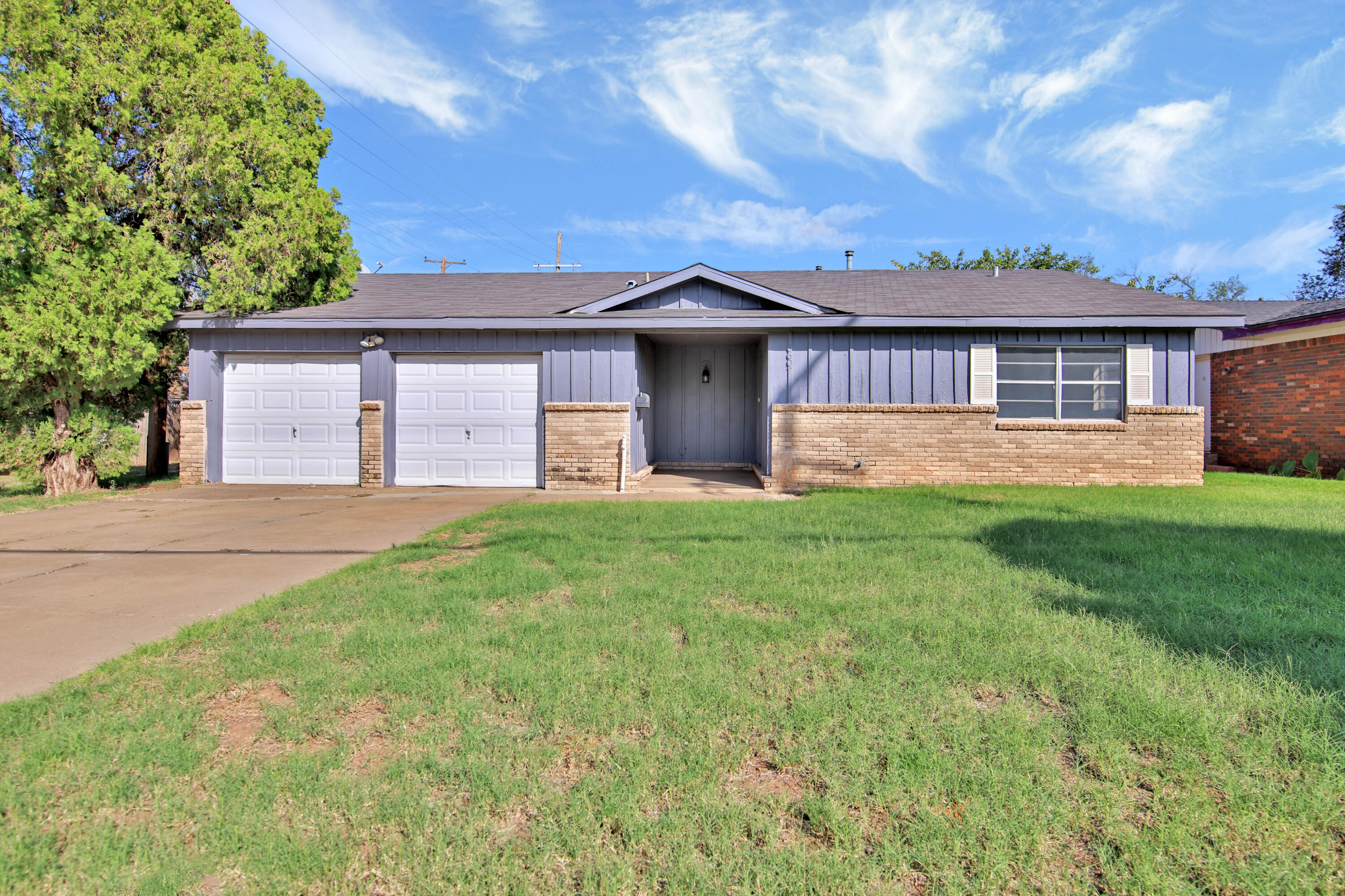 a front view of a house with yard and green space