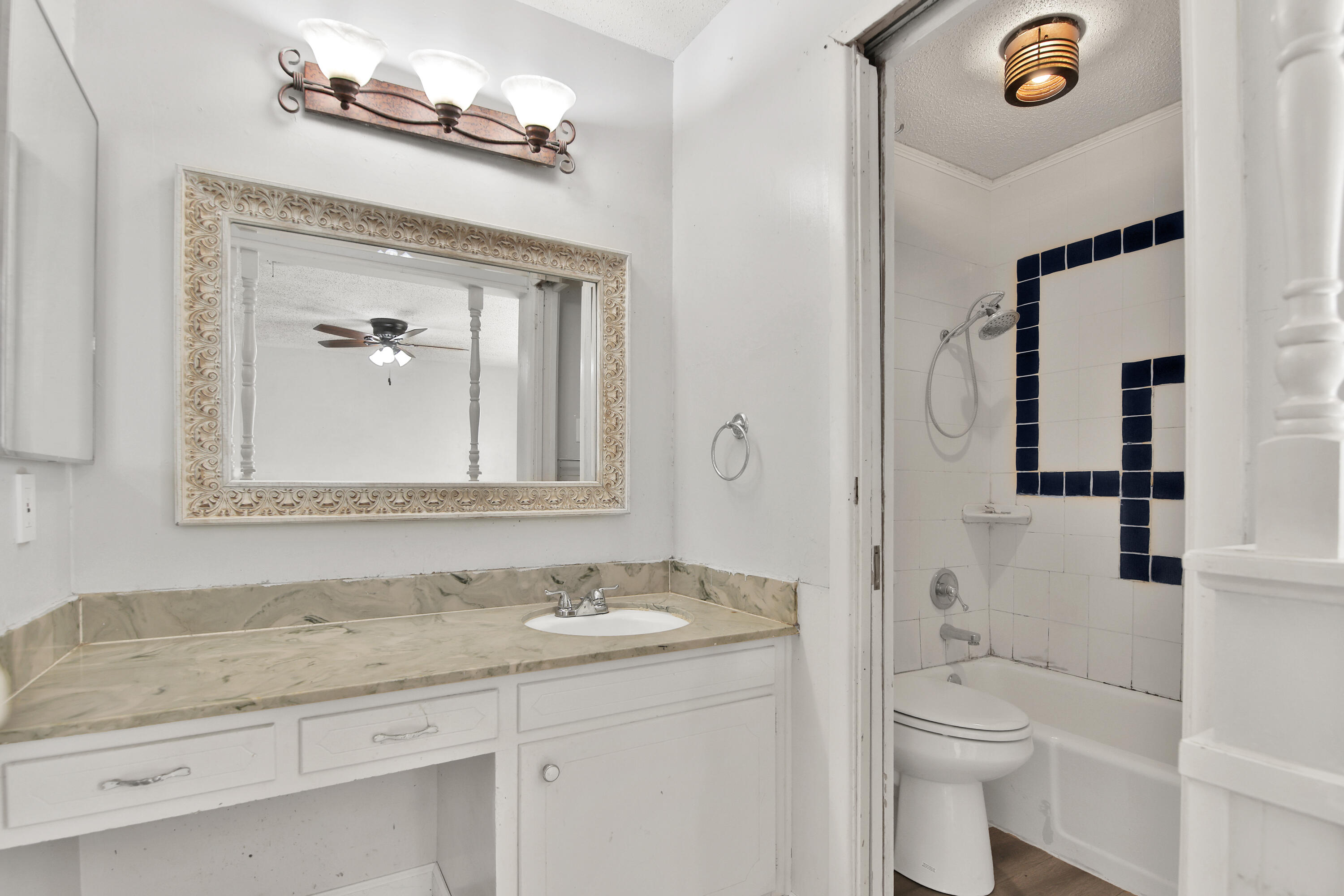 6607 Avenue U Lubbock, TX 79412 - Photo 14 of 25 a bathroom with a granite countertop sink a toilet and a mirror