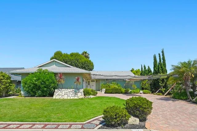 a view of a house with a yard and potted plants