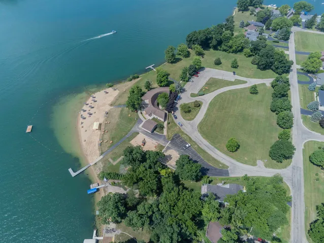an aerial view of a residential houses with outdoor space and trees all around