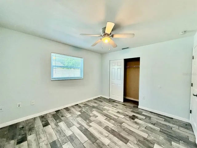 a view of a livingroom with a chandelier fan and wooden floor