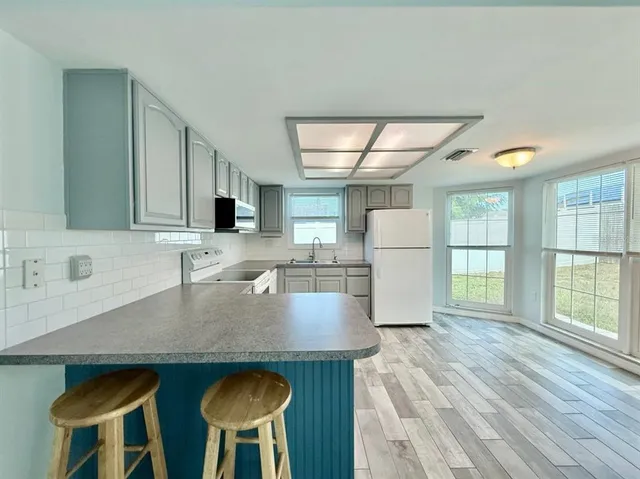 a kitchen with a stove a refrigerator and a sink