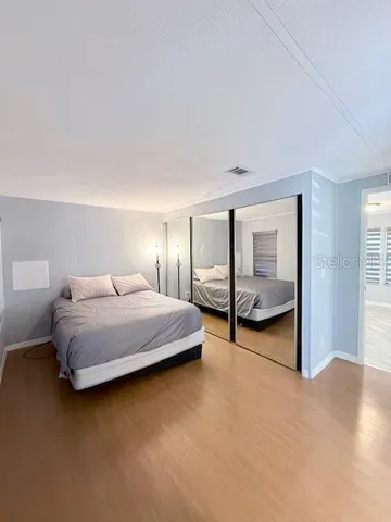 a bedroom with a bed and large mirror