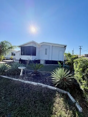 a view of a house with a yard and potted plants