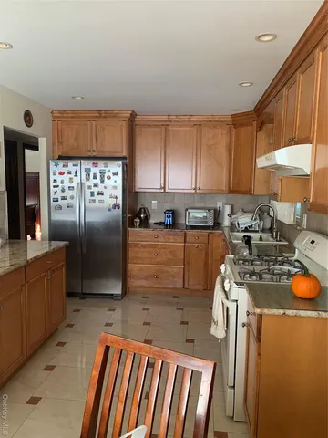 a kitchen with stainless steel appliances granite countertop a stove a sink and a refrigerator