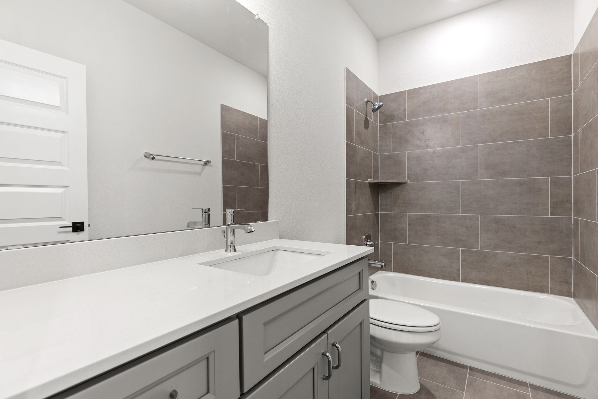 2600 Gattis School Road, Unit 1001 Round Rock, TX 78664 - Photo 27 of 40 A well-lit bathroom features a vanity with sleek counters, complementing the tiled tub and shower combination.