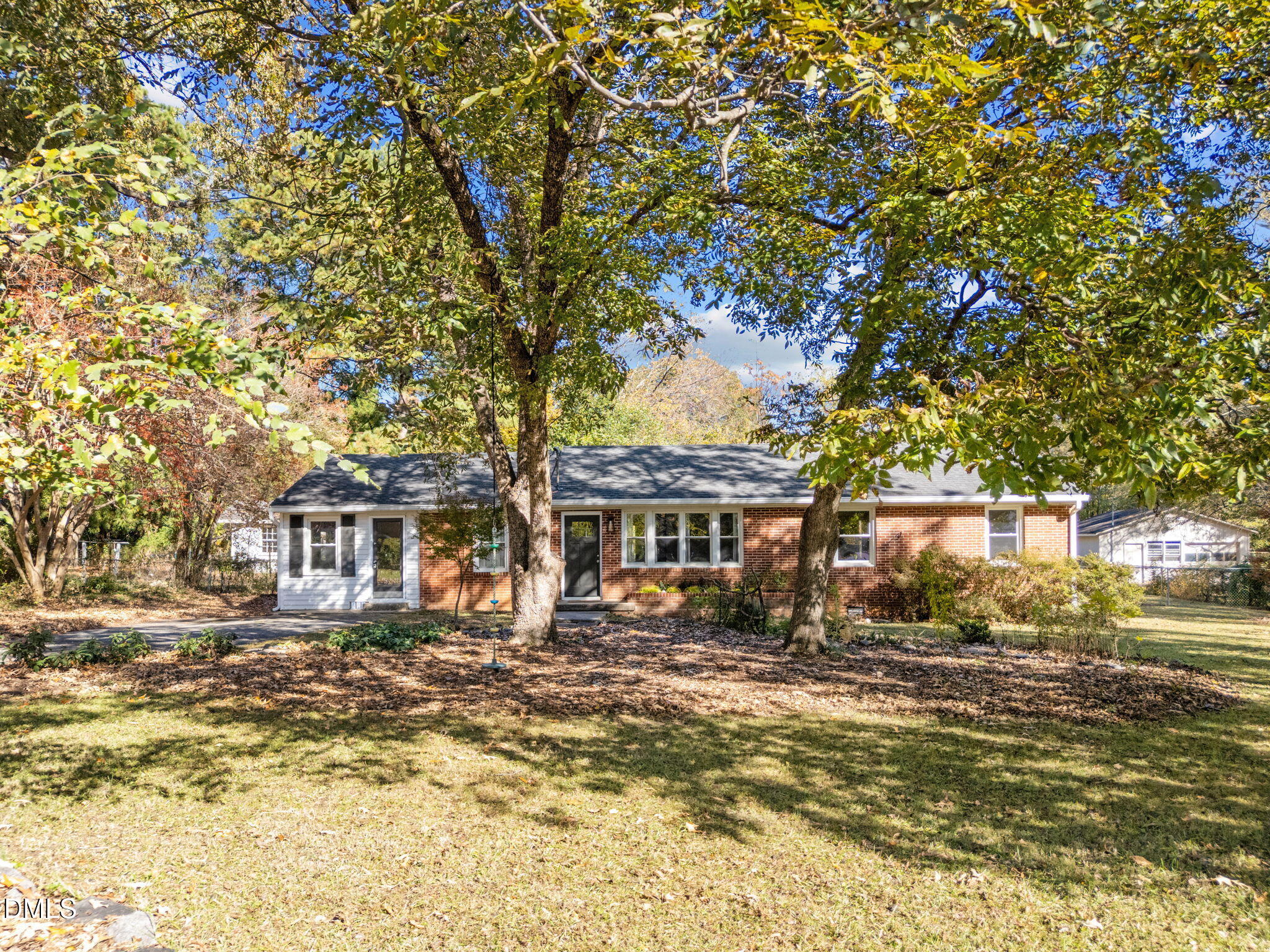 a front view of a house with a yard tree and outdoor seating