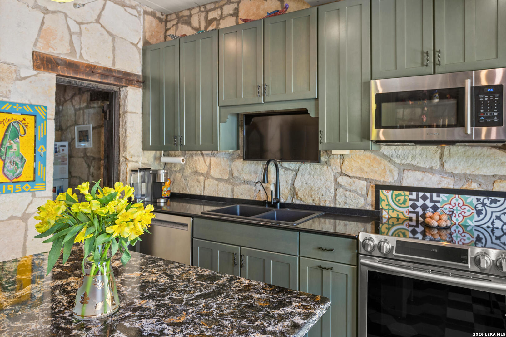132 Ridge Place Boerne, TX 78006 - Photo 25 of 40 a kitchen with stainless steel appliances kitchen island granite countertop a stove a sink and a microwave