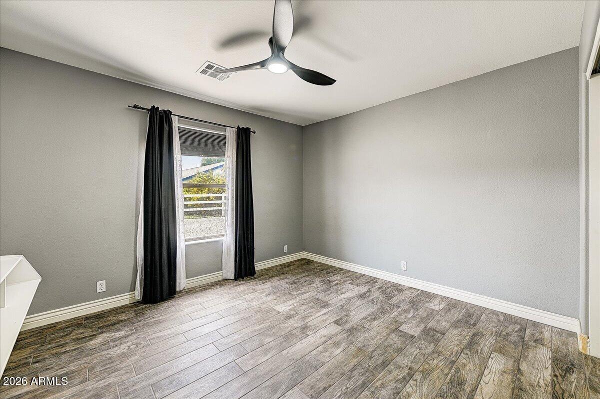 7624 North Citrus Road Waddell, AZ 85355 - Photo 29 of 57 an empty room with wooden floor and windows