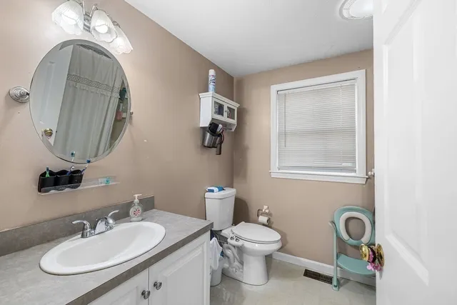 a bathroom with a toilet a sink and mirror