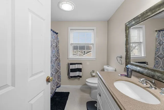 a bathroom with a granite countertop sink toilet and shower