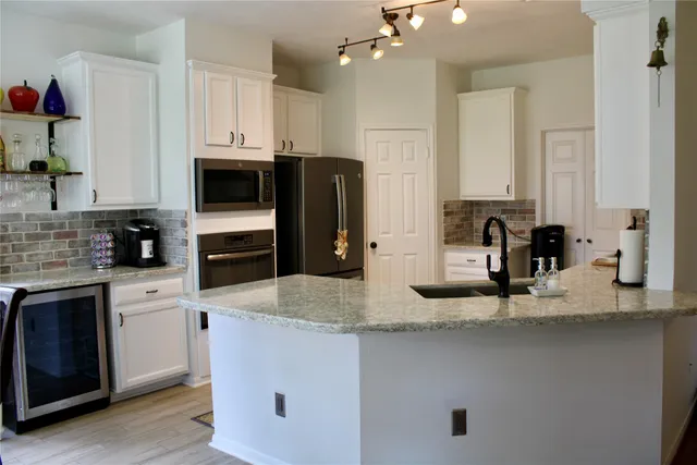 a kitchen with stainless steel appliances granite countertop a sink a stove and a refrigerator