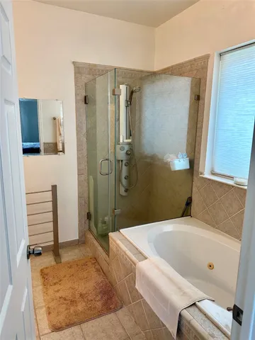 a bathroom with a tub a toilet and a shower