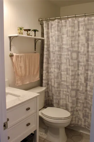 a bathroom with a sink a toilet and shower curtain