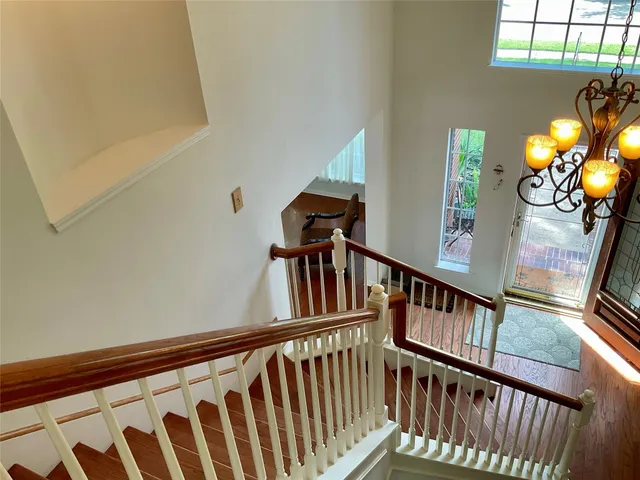 a view of staircase with railing and a chandelier