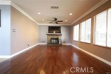 a view of a room with wooden floor and a ceiling fan