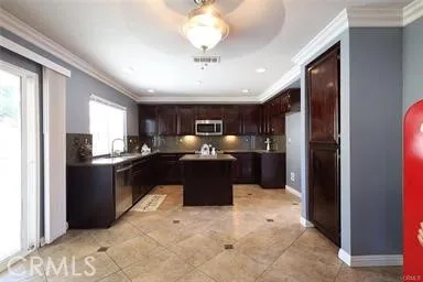 a kitchen with kitchen island granite countertop lots of counter top space and refrigerator