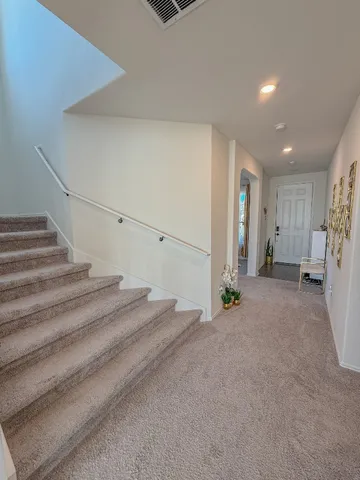 a view of an empty room with stairs and a fireplace