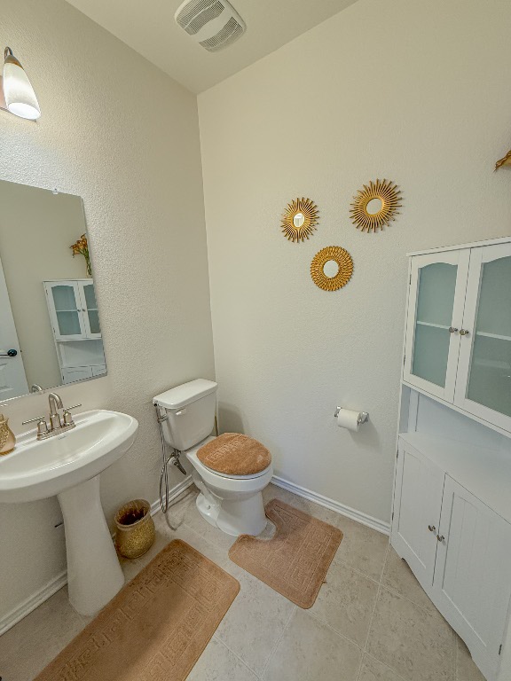 121 Outlaw Drive Jarrell, TX 76537 - Photo 12 of 32 a white toilet sitting next to a bathroom sink