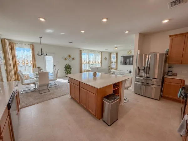 a kitchen with kitchen island a sink a counter and a refrigerator