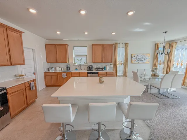 a large white kitchen with a table and chairs