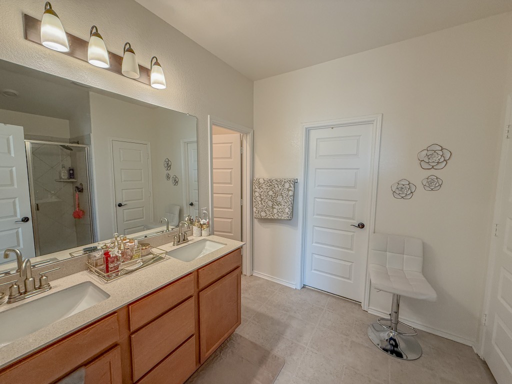 121 Outlaw Drive Jarrell, TX 76537 - Photo 22 of 32 a spacious bathroom with a double vanity sink a mirror and a shower